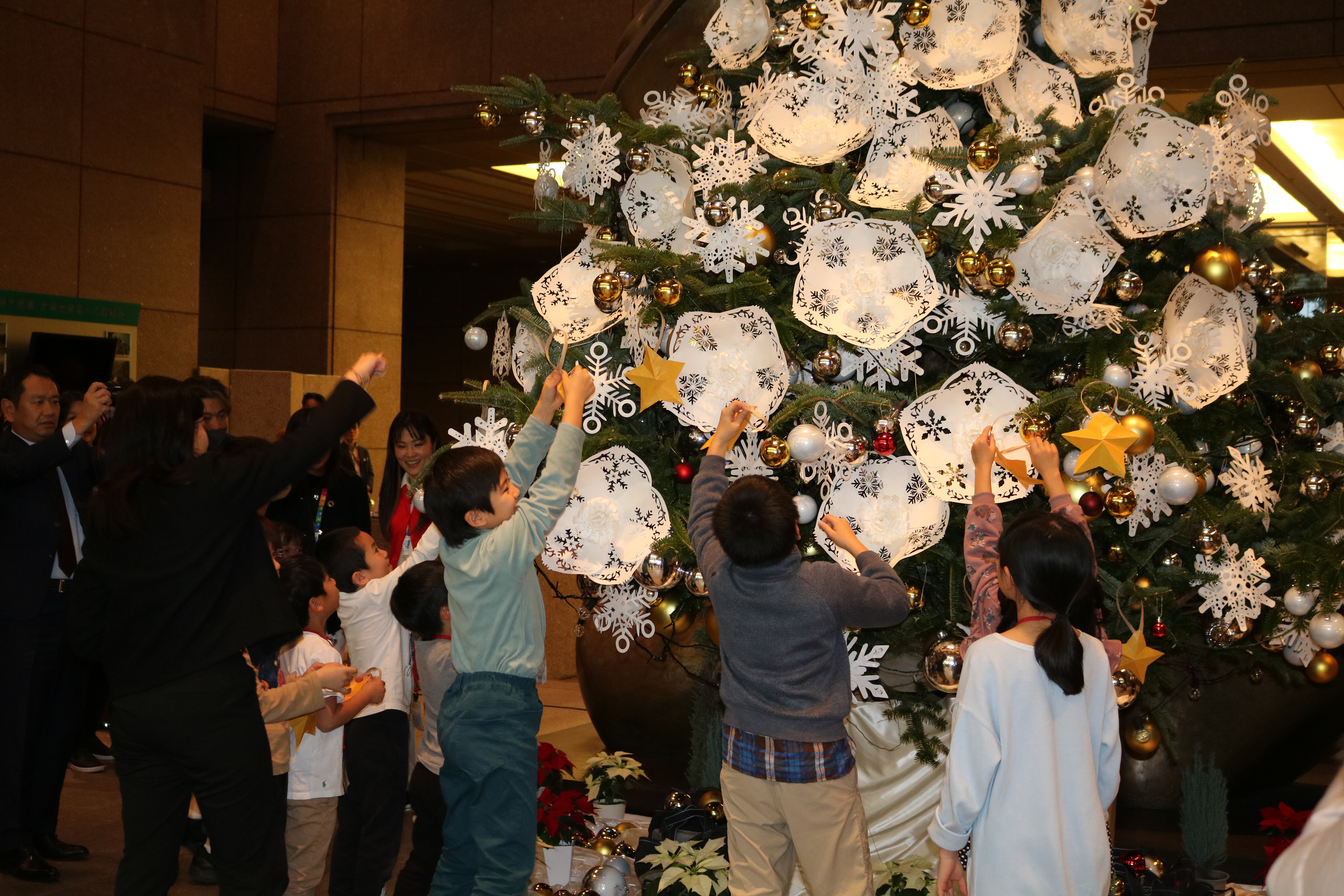 写真：クリスマスツリーに飾り付けをする子供たち