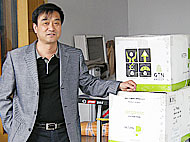 パットスピン社のプレオーガニックコットンの梱包の横に立つ社長